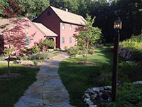 Goshen stone walkway leads to house through gardens.